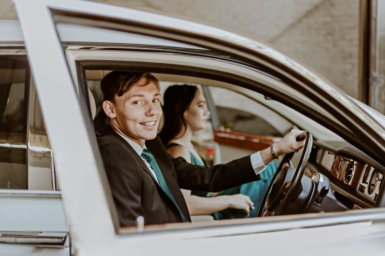 Smiling couple inside a luxury car, highlighting fashion and style in Pretoria, South Africa.